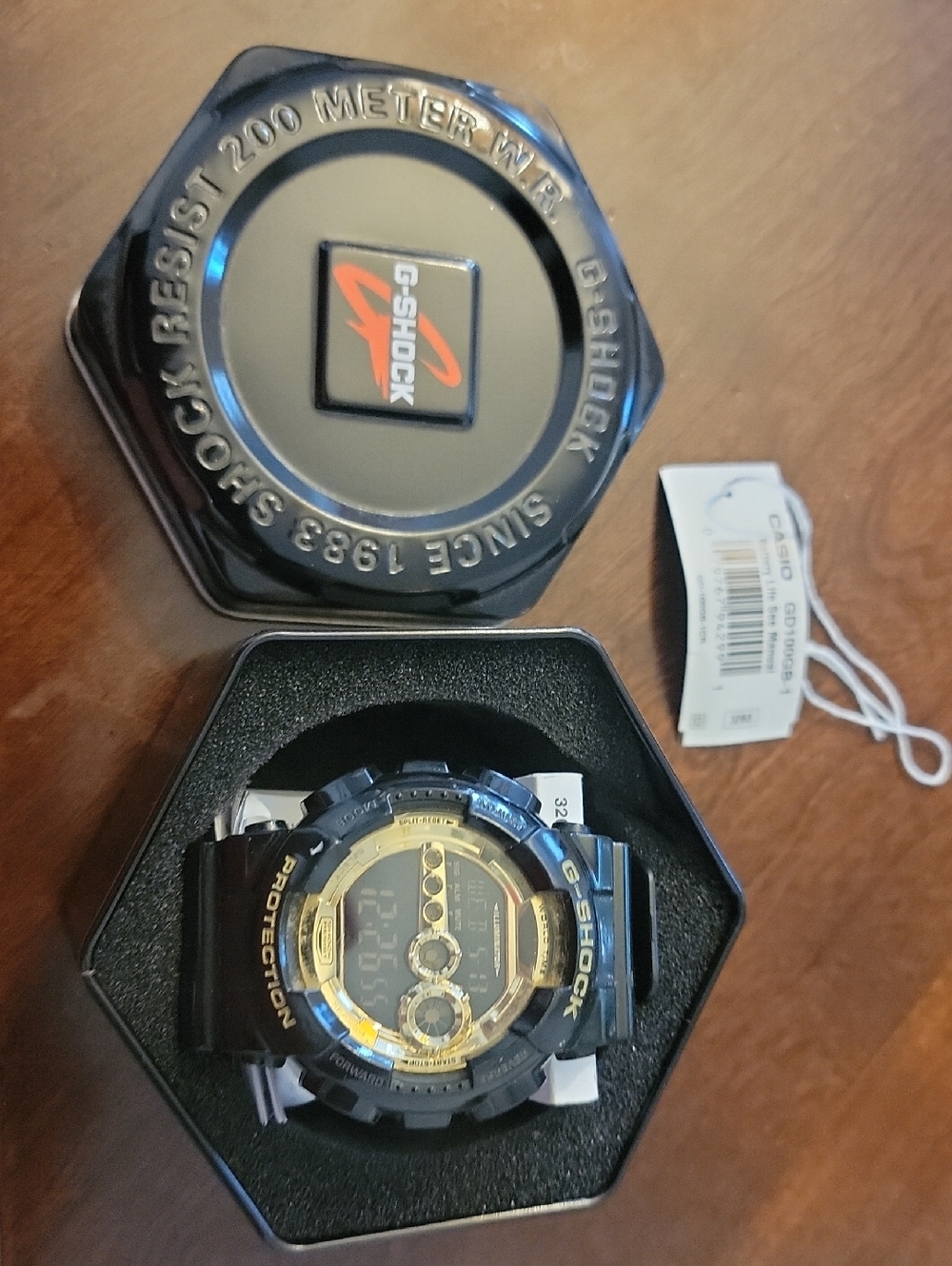 G-Shock GD100GB-1 Black and Gold Resin Sport Watch with Tin Case